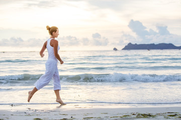 Caucasian woman jogging at seashore