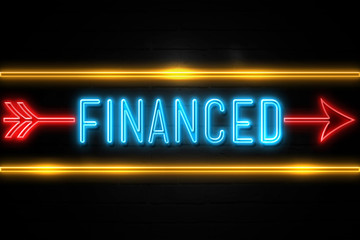 Obraz premium Financed - fluorescent Neon Sign on brickwall Front view