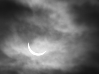 Obraz na płótnie Canvas partial solar eclipse with sun through clouds