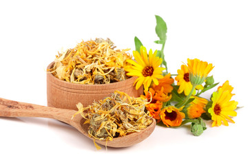 Fresh and dried calendula flowers in a wooden bowl isolated on white background. Marigold - obrazy, fototapety, plakaty