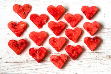 Healthy food with love. Pieces of watermelon in the form of hearts on white wooden background. Top view