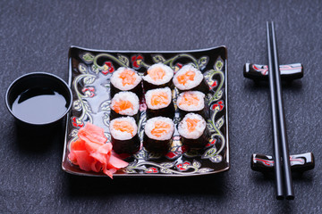 Sushi rolls with salmon, ginger, chopsticks and soy sauce 