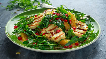 Grilled Halloumi Cheese salad with orange, rocket leaves, pomegranate and pumpkin seed. healthy food