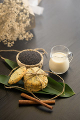 Sesame Cookies, sesame and milk on black wooden background
