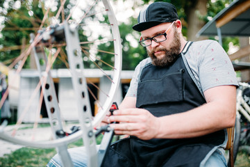 Mechanic adjusts bike spokes and repair wheel