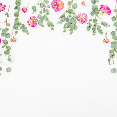 Floral frame of pink roses and eucalyptus on white background. Flat lay, top view
