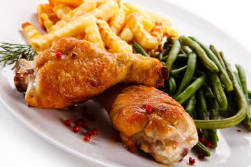 Grilled drumsticks with french fries and vegetables 
