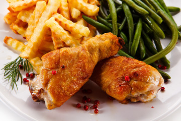 Grilled drumsticks with french fries and vegetables 