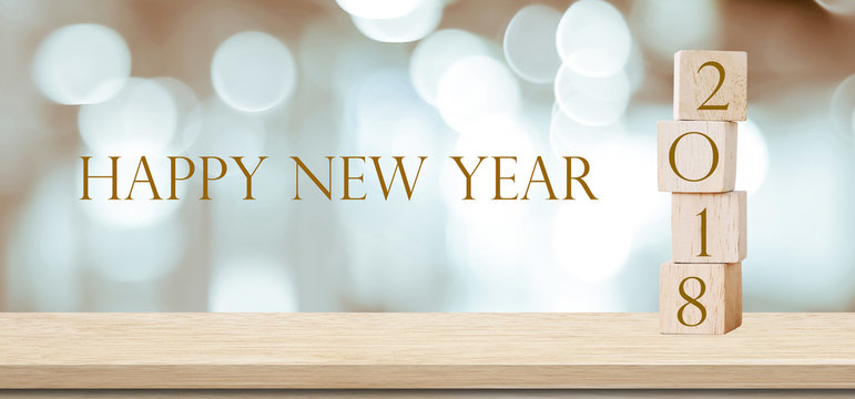 Wooden cubes with 2018 and happy new year over blur bokeh background, new year banner