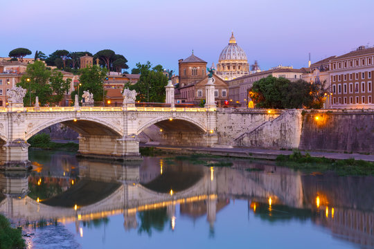View of Tiber River, bridge Vittorio Emanuele II and Saint Peter Cathedral during morning blue hour in Rome, Italy.