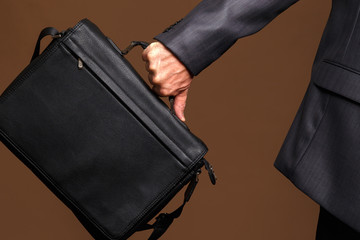 Black leather briefcase in the man's hand. The businessman is in a hurry on business