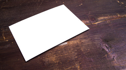 a white blank postcard template for graphic design on a wooden background