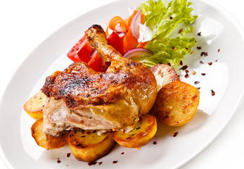 Roast chicken leg with chips on white background