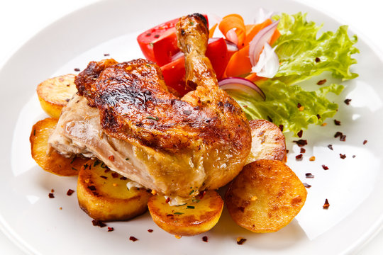 Roast chicken leg with chips on white background
