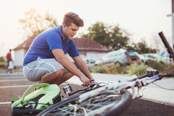Fototapeta na wymiar Teenager boy repair tire on bicycle summer outdoor photo