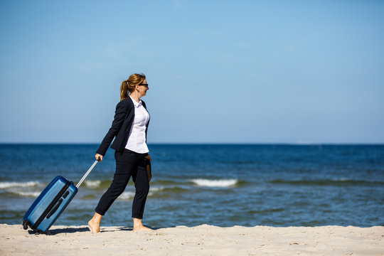 Businesswoman walking on beach