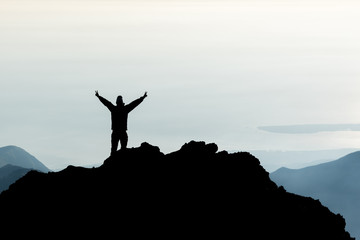 Silhouette of man spreading hand on top of mountain, Mount Rinjani, Lombok island, Indonesia