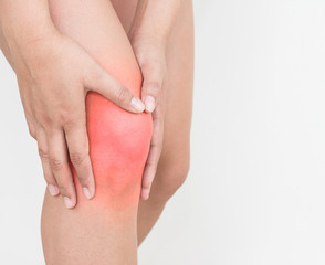 Young woman with hands holding knee pain isolated on white background.