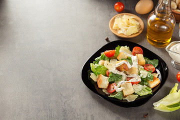 caesar salad and ingredients at table
