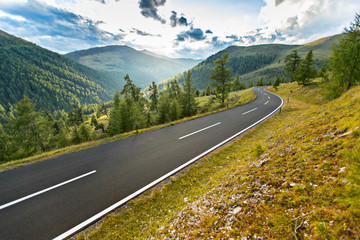 Obraz premium Droga asfaltowa w Austrii, Alpy w letni dzień.