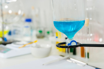 Close up of a part of glass flask with blue liquid