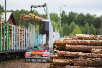 Fototapeta na wymiar Loading of timber on railway carriages. Loader in work
