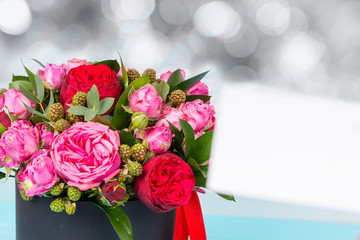 Beautiful bouquet of pink and red roses, blank gift tag with copy space on a background
