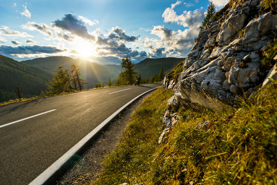 Motorcycle driver riding in Alpine highway, Nockalmstrasse, Austria, Europe.