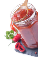 tomato sauce in glass jar on white