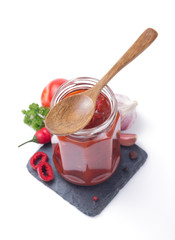 tomato sauce in glass jar on white