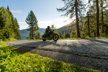 Fototapeta na wymiar Motorcycle driver riding in Alpine highway, Nockalmstrasse, Austria, Europe.