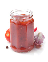 tomato sauce in glass jar on white