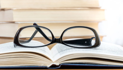 Black glasses on the opened book.