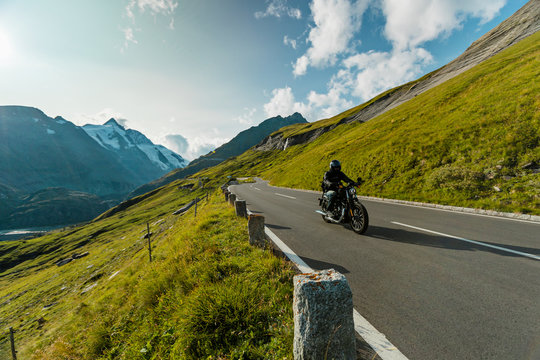 Motorcycle driver riding in Alpine highway on famous Hochalpenstrasse, Austria, Europe.