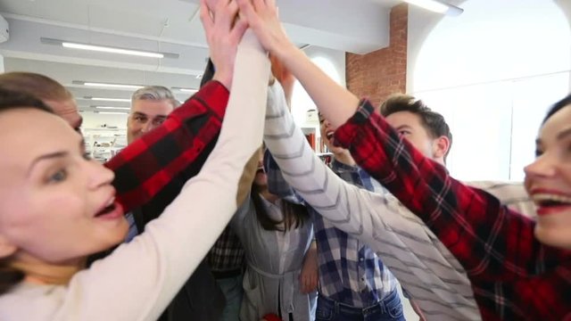 Cheerful team of people doing high five after playing table football