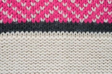 Texture of a beige knitted sweater close-up. Three-color pattern knitted winter sweater