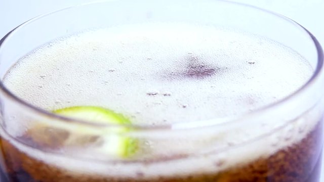 Bubbles in a foamy iquid with Brown Drink Air bubble and slices of lime and mint leaves. Releasing bubbles and foaming