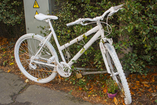 The modern phenomenon of a memorial Ghost Bike chained to a post at the scene of a tragic fatal accident involving a motor vehicle and a cyclist on the road to Bangor Co Down from Belfast
