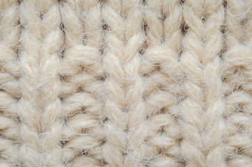 The texture of fabric thick beige sweater close-up. Knitted texture background