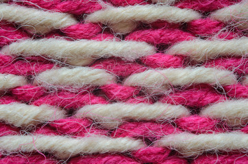 Texture of a beige and red knitted sweater close-up. Abstract pattern of winter sweater