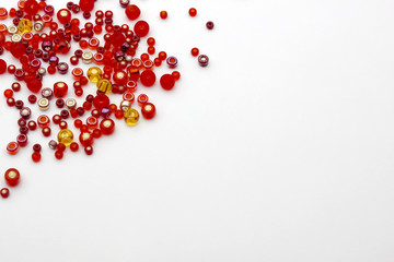 Colorful red beads on the light background. Selective soft focus. Place for text, copy space.