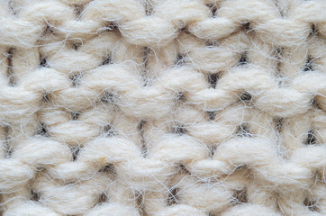 The texture of fabric thick beige sweater close-up. Knitted texture background