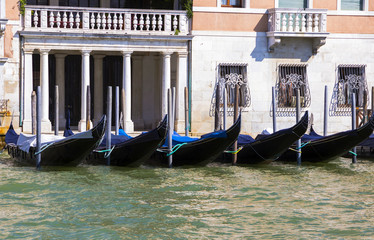 Fototapeta na wymiar Parking gondolas on the pier in Grand Canal, Venice, Italy