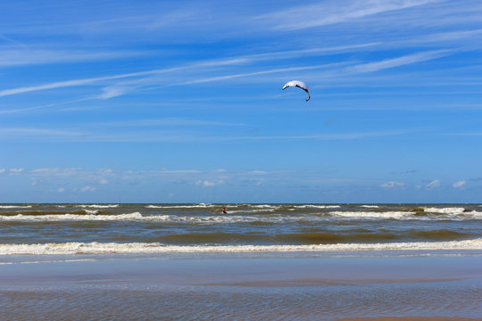 The kitesurfer on the water surface of the sea.