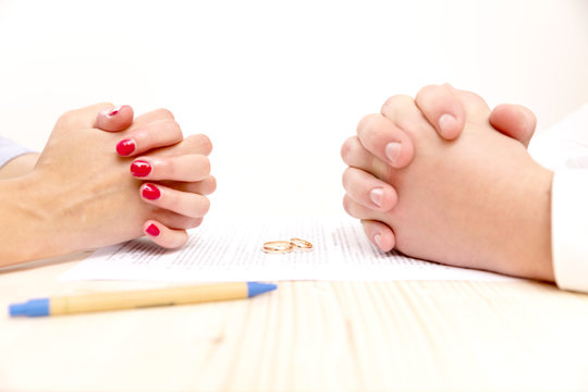 Closeup of a young man an a young woman signing a prenuptial agreement