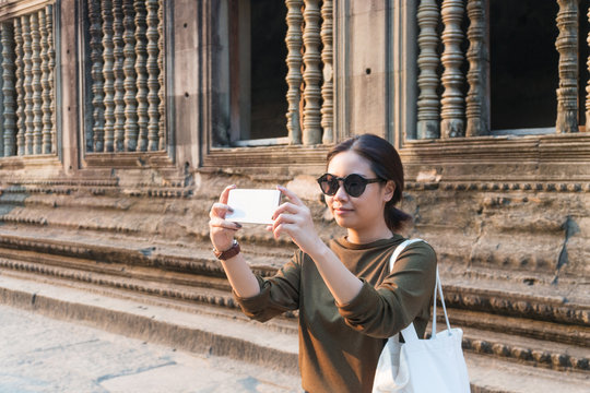 Female traveler taking photo with her smartphone in angkor wat siem reap cambodia