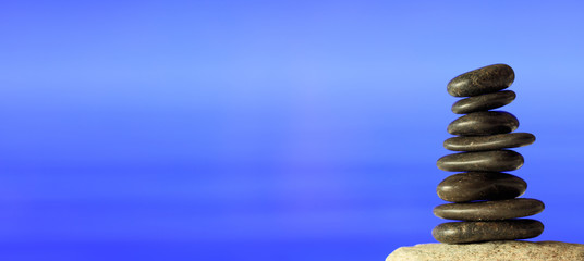 Obraz premium Zen stones stack on blue sea background