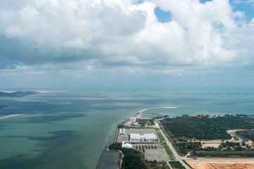 Aerial view of sea beach and city, airport and ship bay with cloudy blue sky background