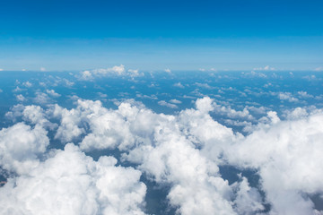 White clouds and bright blue sky horizon, aerial view from above cloud atmosphere, view from airplane