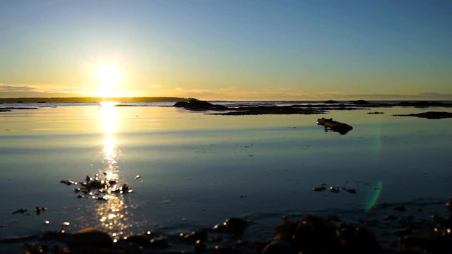 Sunset in Rimouski, Quebec by Saint Lawrence river in Gaspesie region of Canada with closeup of water shore and waves